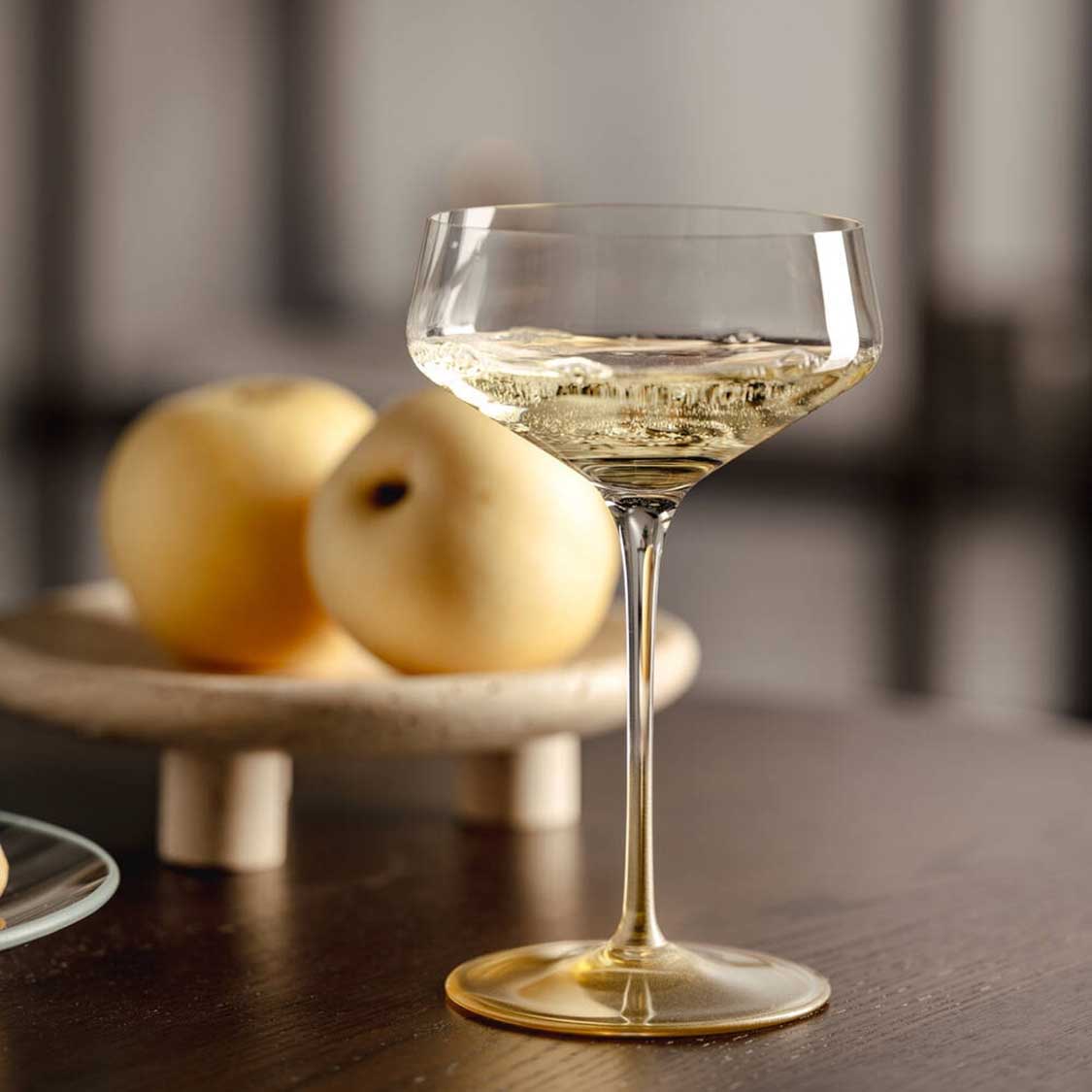 Champagnerschale PUCCINI mit Wein gefüllt, Birnen im Hintergrund auf Tisch