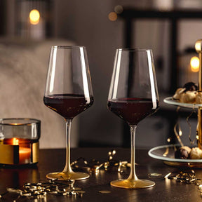 Weinglas PUCCINI 560 ml gold 2er-Set mit Rotwein auf gedecktem Tisch