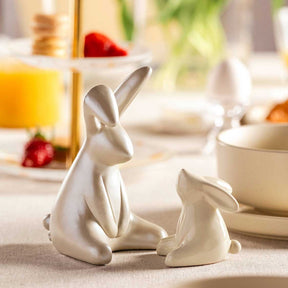 Hase LOLA sitzt auf gedecktem Frühstückstisch neben Schale und Orangensaft