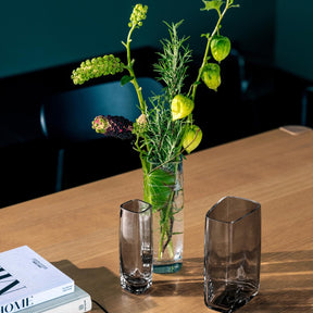 Solifleurvase PIETRA mit grünen Pflanzen auf Holztisch neben Magazinen