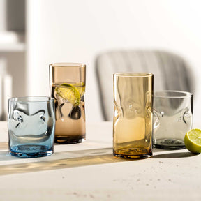 Trinkgläser VESUVIO in Amber und Blau mit Wasser, Limette und Getränken auf heller Oberfläche