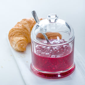 Geleedose DELIGHT mit rotem Inhalt, Löffel und Croissant auf weißem Untergrund