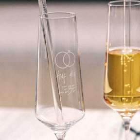 Sektglas PUCCINI mit persönlicher Gravur, daneben gefülltes Sektglas