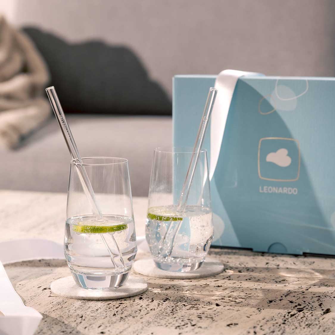 Trinkglas Geschenkset PUCCINI mit Glashalmen auf Betonoberfläche, Verpackung im Hintergrund