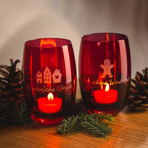 Zwei rote Tischlichter CHEERS mit brennenden Kerzen, Gravuren und Weihnachtsdeko