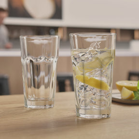 Zwei Trinkgläser ROCK auf Holztisch, eines leer, eines mit Wasser, Eis und Zitronenscheibe gefüllt
