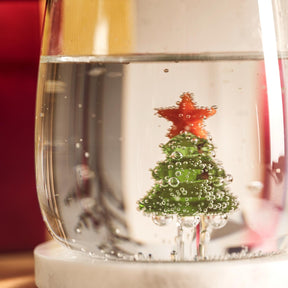 Trinkglas RIPOSO mit Wasser gefüllt, Weihnachtsmotiv aus Tannenbaum und rotem Stern
