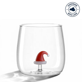 Trinkglas RIPOSO mit roter Weihnachtsmütze auf dem Boden innen